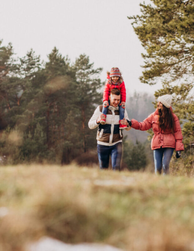 Young family together walking in forest at winter time Young family together walking in forest at winter time